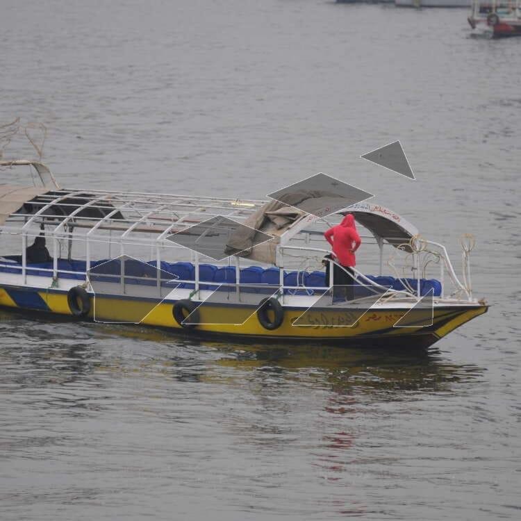 A boat in the middle of the Nile with a woman standing on it, enjoying the view of the river and the surrounding cityscape.