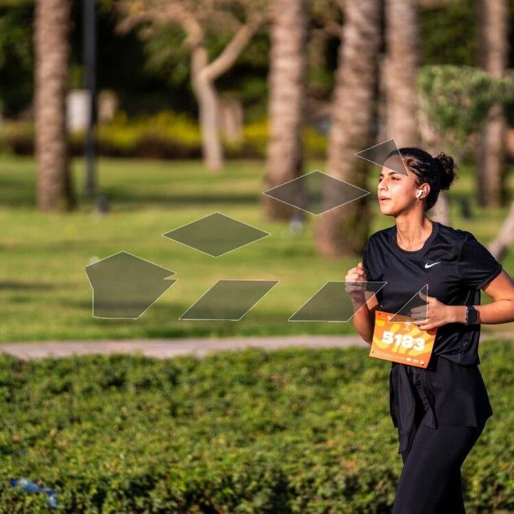 A woman takes part in the Madinaty Marathon, running with energy and determination.