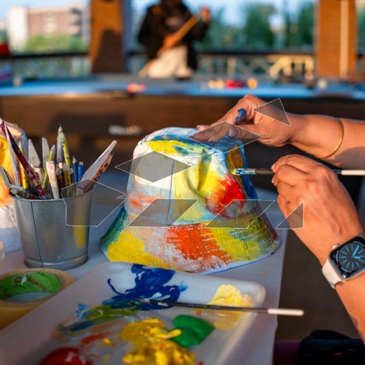 Image of a woman delicately painting a white hat