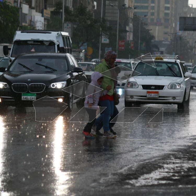 A woman and a child hurry across a busy street in Cairo, Egypt.