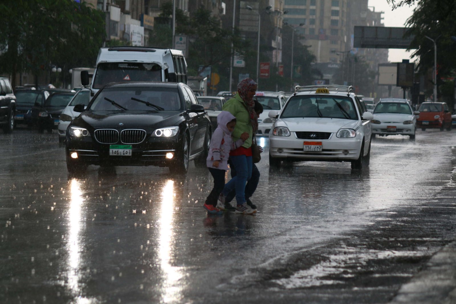 A woman and a child hurry across a busy street in Cairo, Egypt.