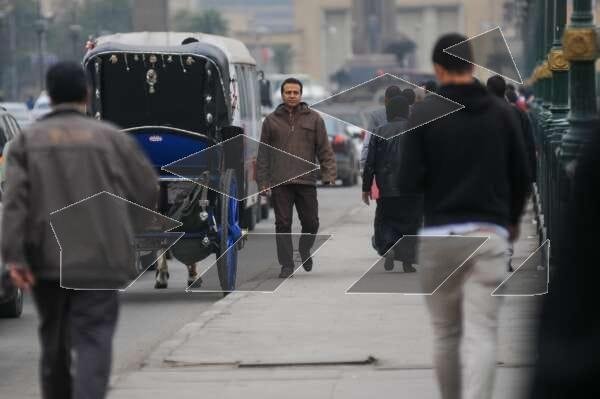 A street scene in Cairo, Egypt, showing a traditional horse-drawn carriage (hantour)