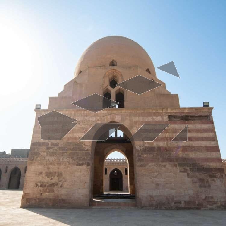 Architectural view of the central dome and spiral minaret of the historic Ahmad Ibn Tulun Mosque in Old Cairo, Egypt.