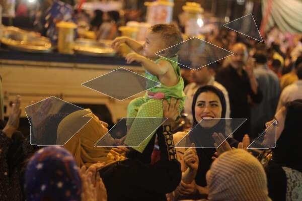Women Carrying Children on Their Shoulders During Festive Mawlid Celebration – Cairo, Egypt