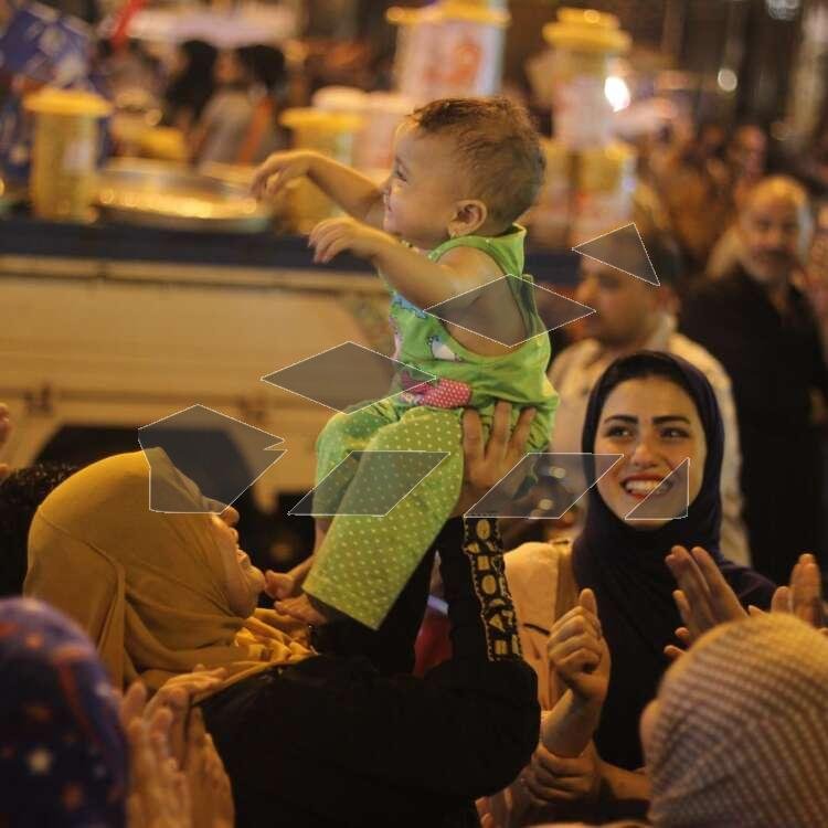 Women Carrying Children on Their Shoulders During Festive Mawlid Celebration – Cairo, Egypt