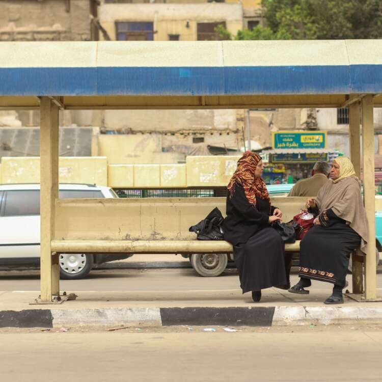 Two Women Sitting and Waiting for the Bus at a Station in Cairo
