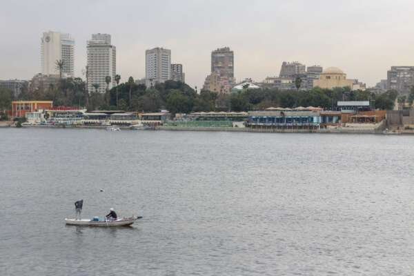 Fishing Boat on the Nile with Cloudy Sky and Cairo Skyline Fishing Boat on the Nile with Cloudy Sky and Cairo Skyline