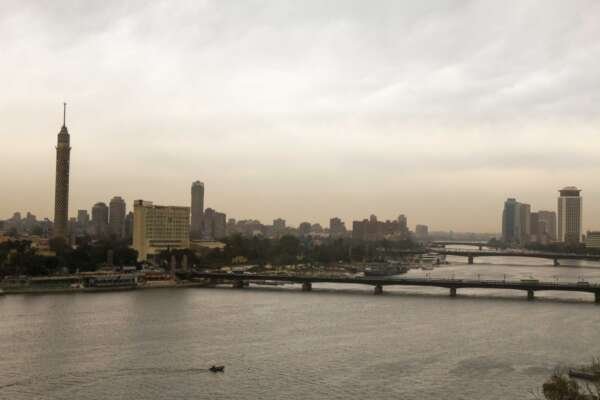 Fishing Boat on the Nile with Cloudy Sky and Cairo Skyline