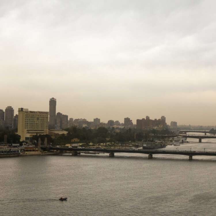 Fishing Boat on the Nile with Cloudy Sky and Cairo Skyline