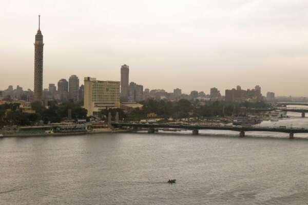 Fishing Boat on the Nile with Cloudy Sky and Cairo Skyline Fishing Boat on the Nile with Cloudy Sky and Cairo Skyline