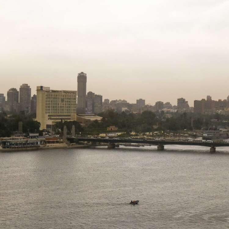 Fishing Boat on the Nile with Cloudy Sky and Cairo Skyline