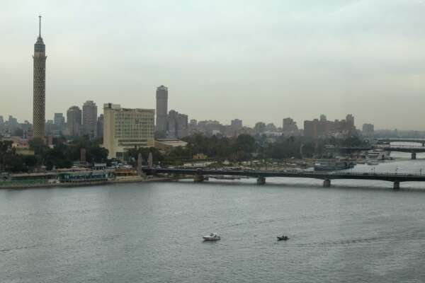 Fishing Boat on the Nile with Cloudy Sky and Cairo Skyline