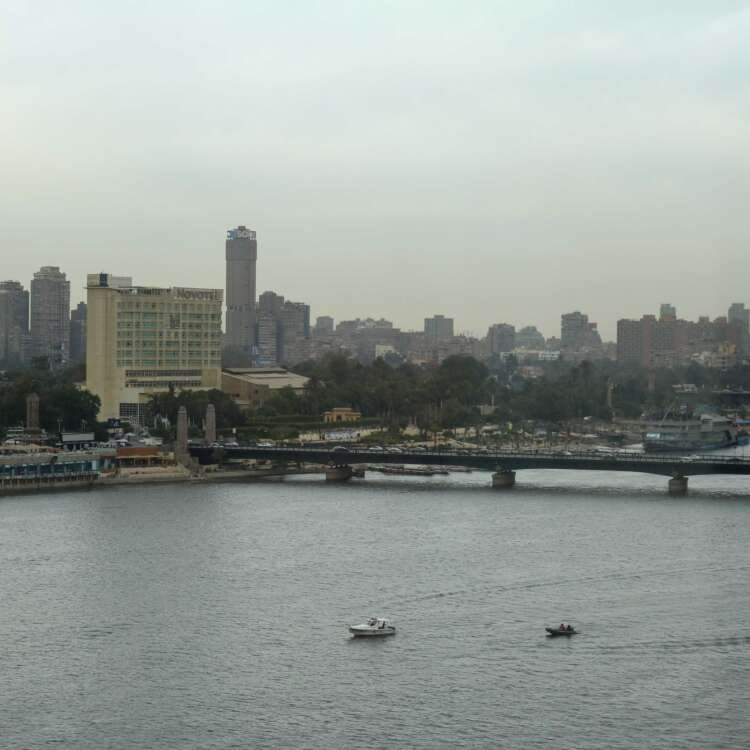Fishing Boat on the Nile with Cloudy Sky and Cairo Skyline