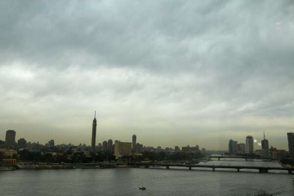Fishing Boat on the Nile with Cloudy Sky and Cairo Skyline