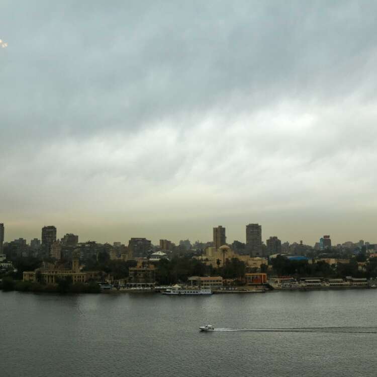 Boat on the Nile with Cloudy Sky, Cairo Skyline, and Cairo Tower