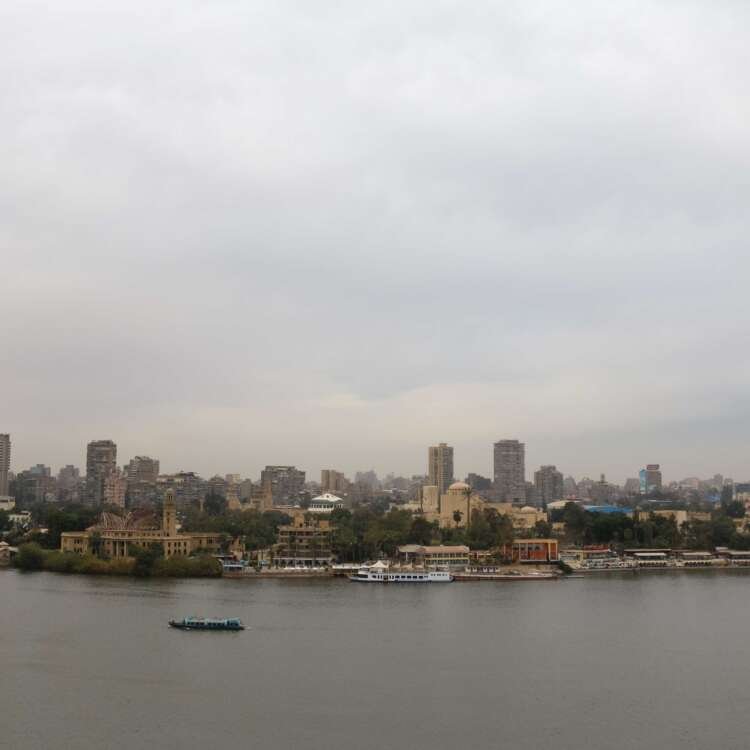 Boat on the Nile with Cloudy Sky, Cairo Skyline, and Cairo Tower
