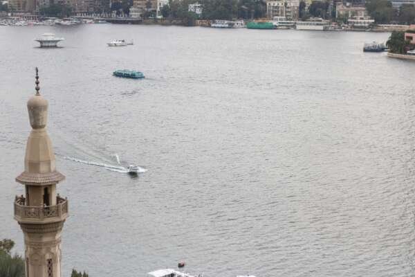 Fishing Boat on the Nile with Cloudy Sky and Cairo Skyline