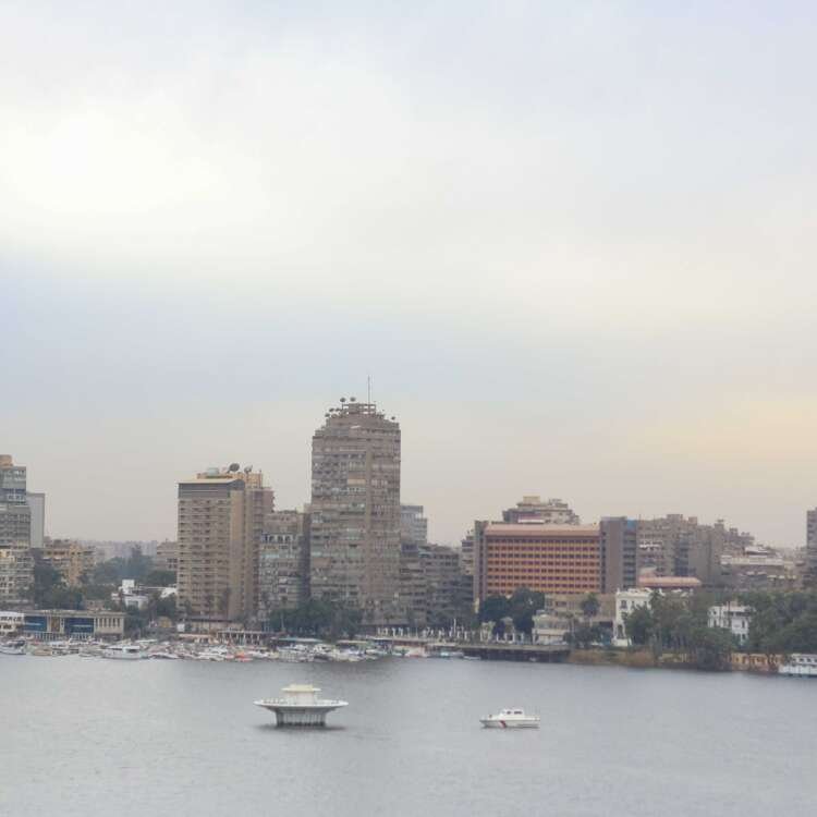 Boat on the Nile with Cloudy Sky, Cairo Skyline, and Cairo Tower
