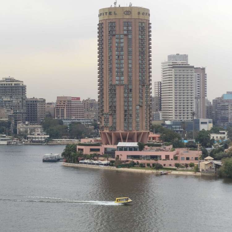 Boat on the Nile with Cloudy Sky, Cairo Skyline, and Cairo Tower
