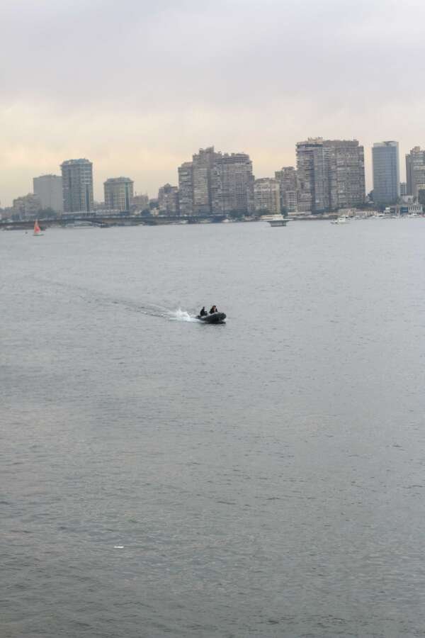 Boat on the Nile with Cloudy Sky, Cairo Skyline, and Cairo Tower