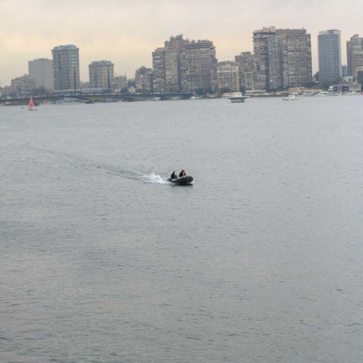 Boat on the Nile with Cloudy Sky, Cairo Skyline, and Cairo Tower