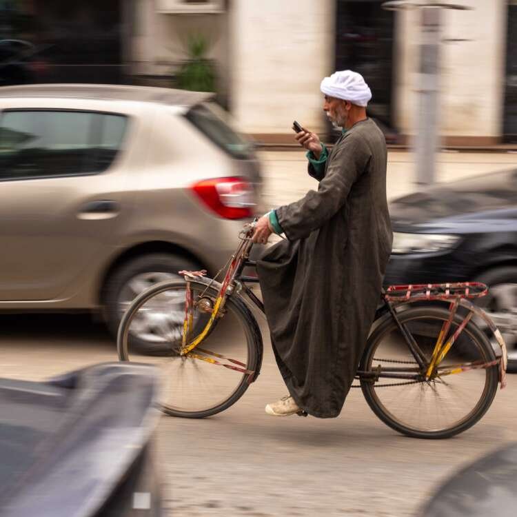 Saidi Man Riding a Bicycle While Using a Mobile Phone in Cairo
