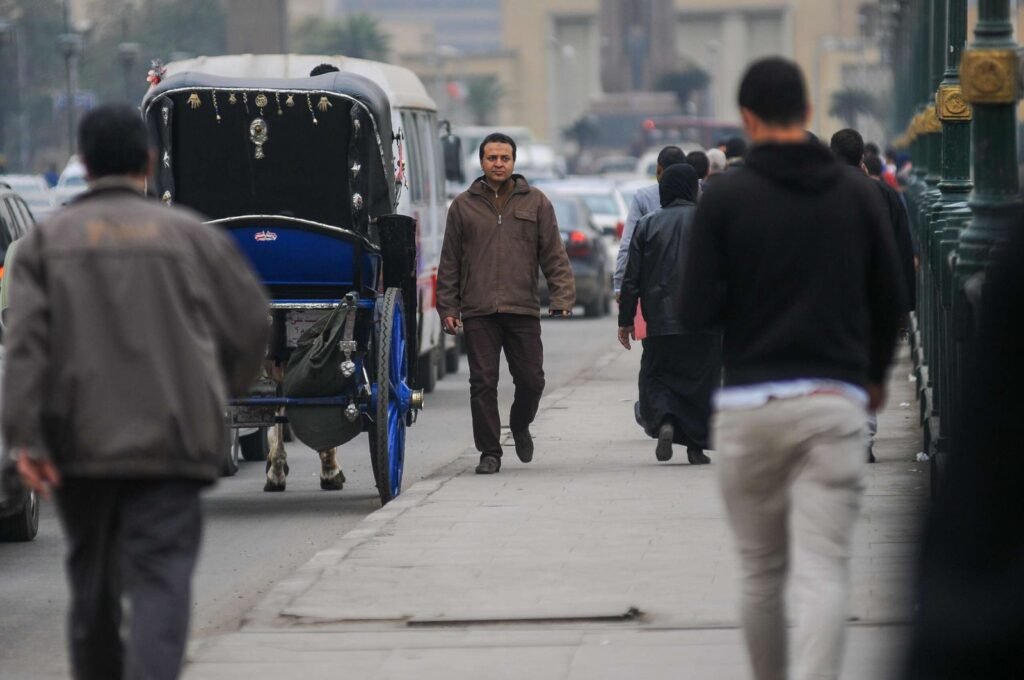 A street scene in Cairo, Egypt, showing a traditional horse-drawn carriage (hantour)