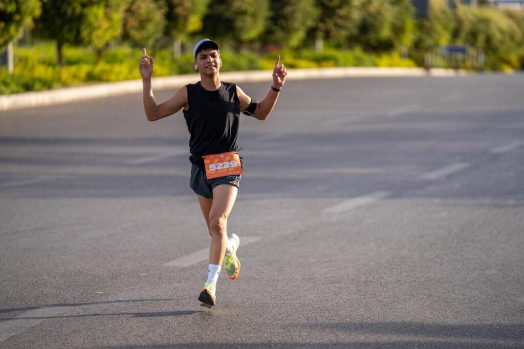 A man participates in the Madinaty Marathon, running with focus and determination.