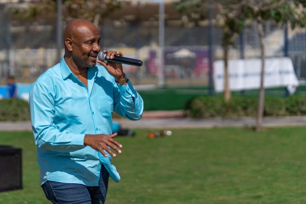 A person singing at a Christmas celebration in a garden during the day