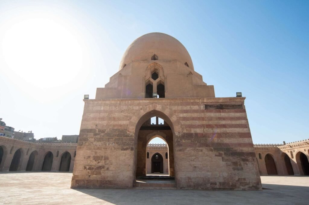 Architectural view of the central dome and spiral minaret of the historic Ahmad Ibn Tulun Mosque in Old Cairo, Egypt.