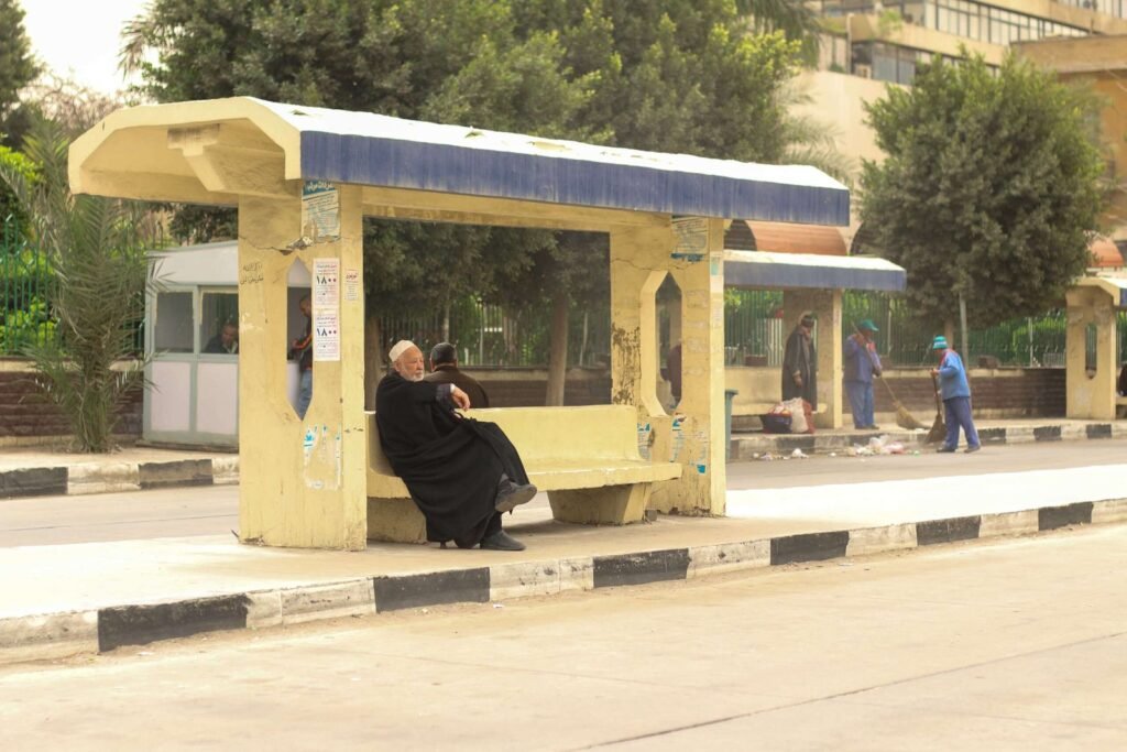 Man Sitting at Bus Station in Abbassia, Cairo, Holding a Cane 4