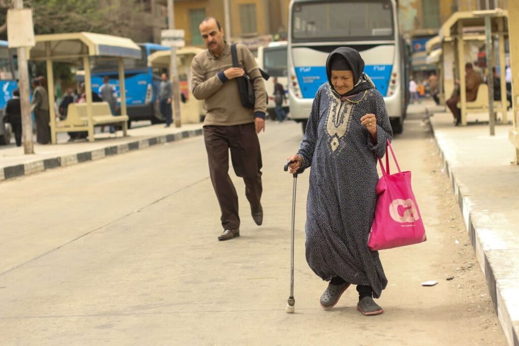 Woman Walking with a Cane Inside a Bus Station in Cairo
