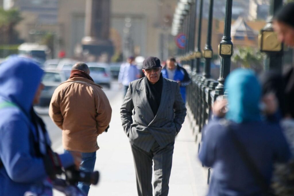 A man in a suit walking on Qasr El Nil Bridge during Eid