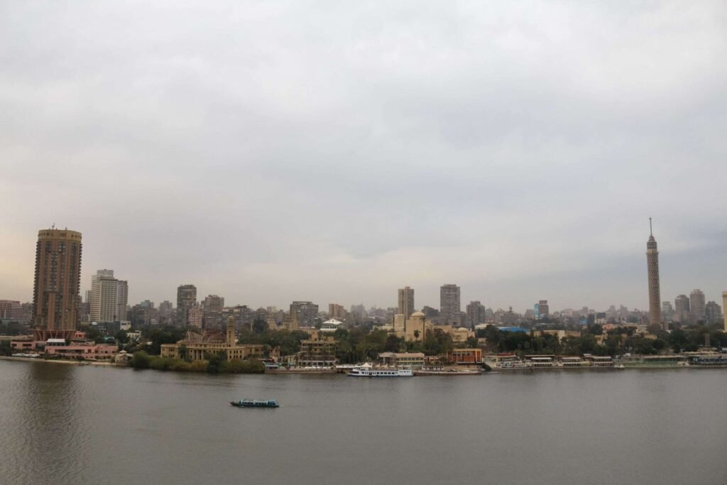 Boat on the Nile with Cloudy Sky, Cairo Skyline, and Cairo Tower