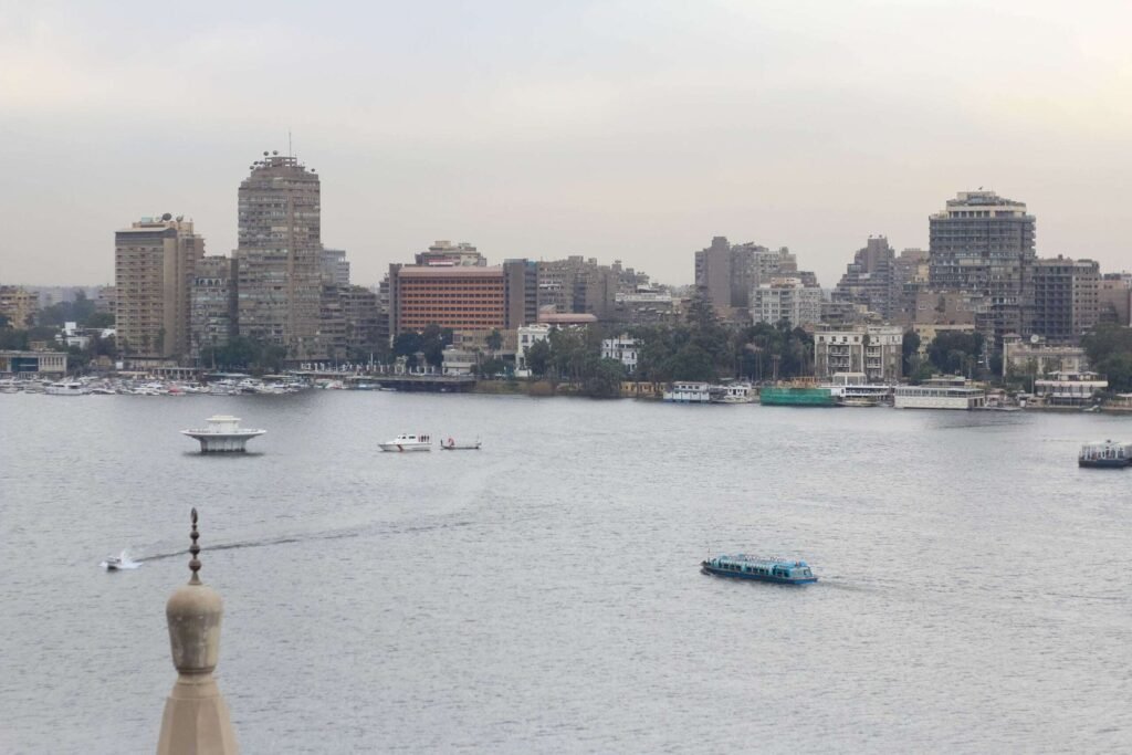 Boat on the Nile with Cloudy Sky, Cairo Skyline, and Cairo Tower