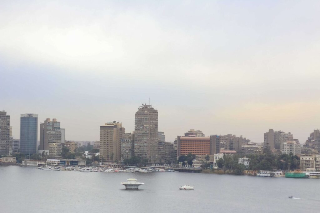 Boat on the Nile with Cloudy Sky, Cairo Skyline, and Cairo Tower