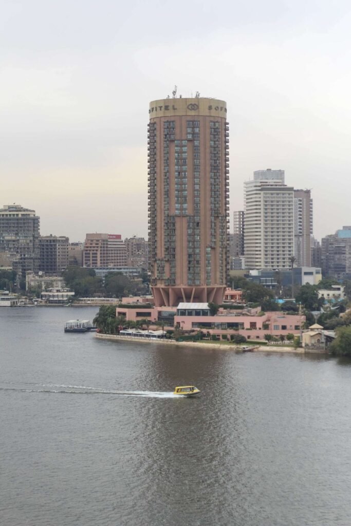 Boat on the Nile with Cloudy Sky, Cairo Skyline, and Cairo Tower
