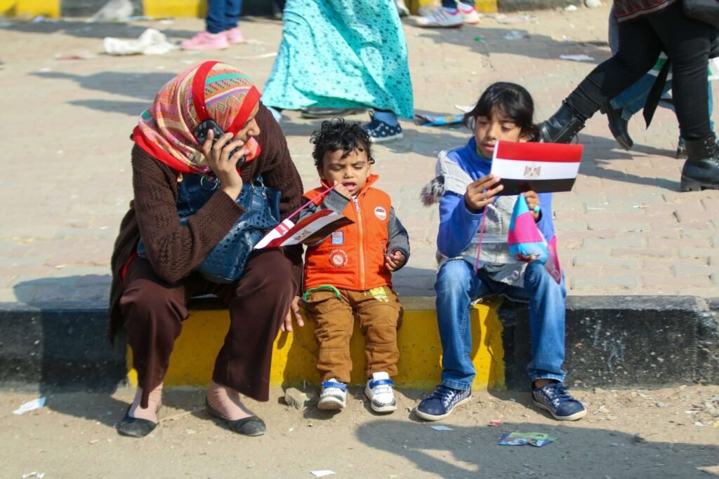 Mother and Children Holding Egyptian Flag in Cairo Street Scene