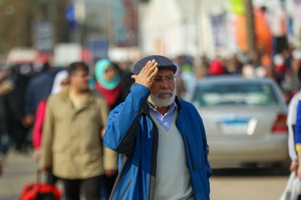 Elderly Man Shielding His Eyes from the Sun at Cairo International Book Fair – 2017