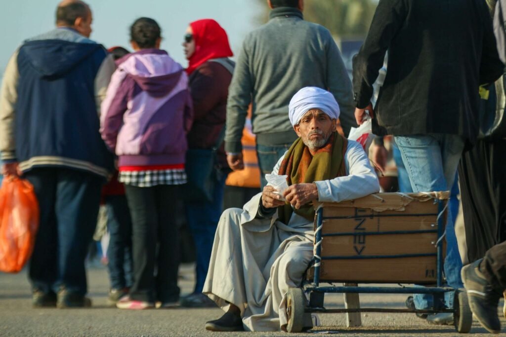Worker with Upper Egyptian features sitting on a metal cart at the Cairo International Book Fair