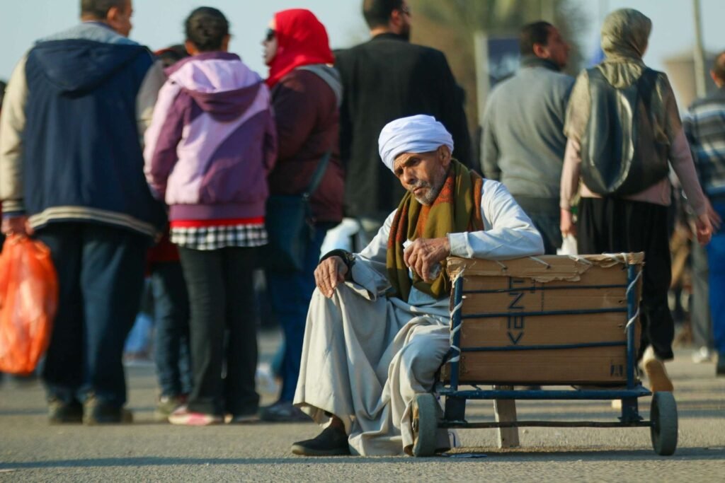 Worker with Upper Egyptian features sitting on a metal cart at the Cairo International Book Fair