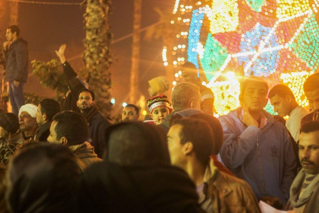 Women Carrying Children on Their Shoulders During Festive Mawlid Celebration – Cairo, Egypt