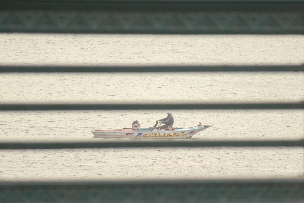 A man sails a traditional faluka boat on the Nile River in Cairo