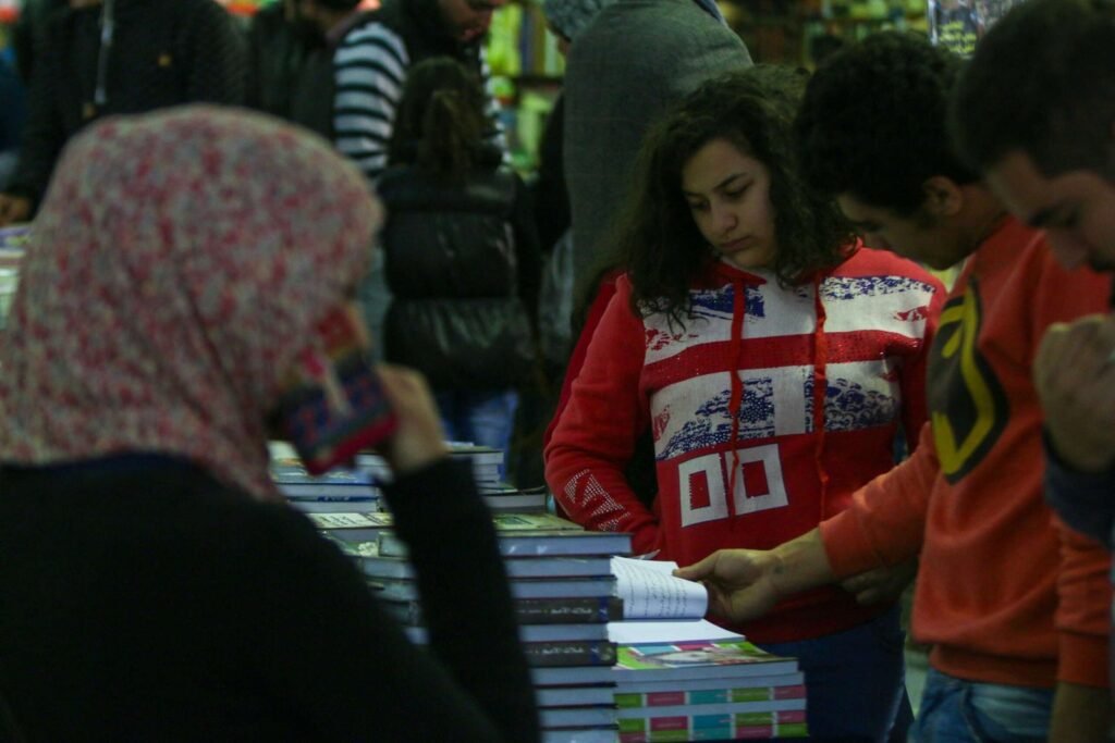 Group of Young People Browsing Books at Cairo International Book Fair – 2017