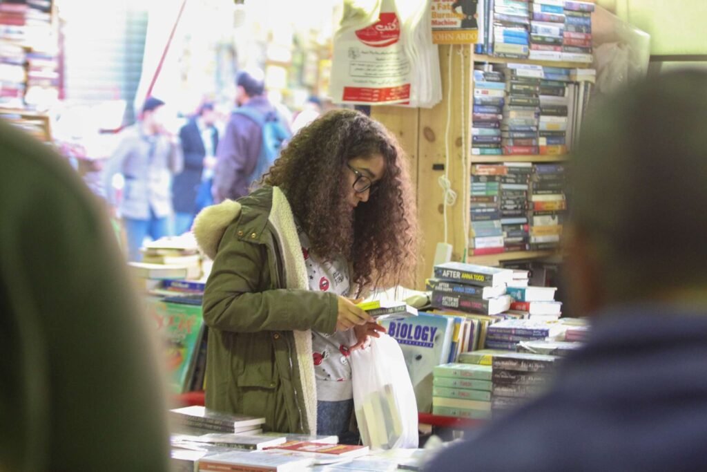 Curly-Haired Girl Reading a Book at Cairo International Book Fair – 2017 2