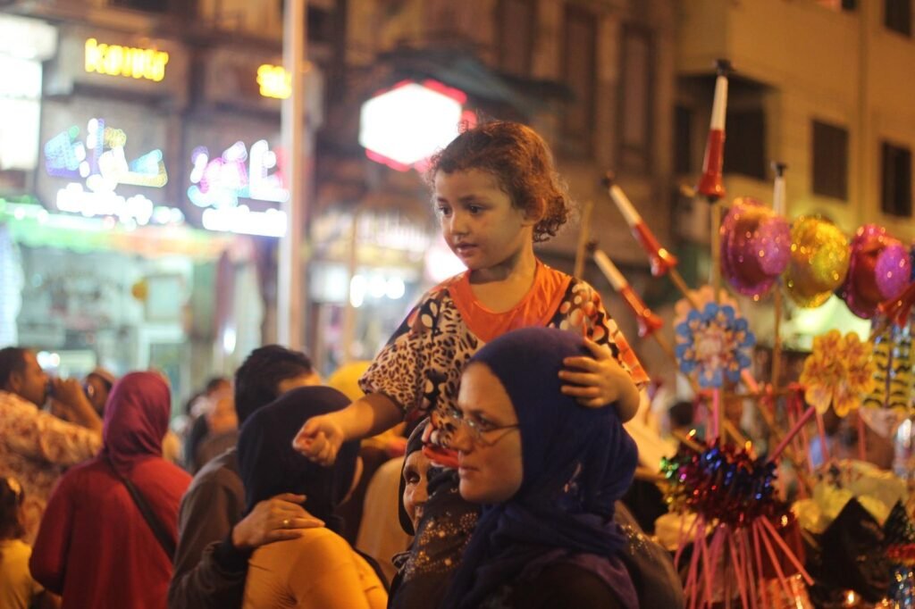 Women Carrying Children on Their Shoulders During Festive Mawlid Celebration – Cairo, Egypt