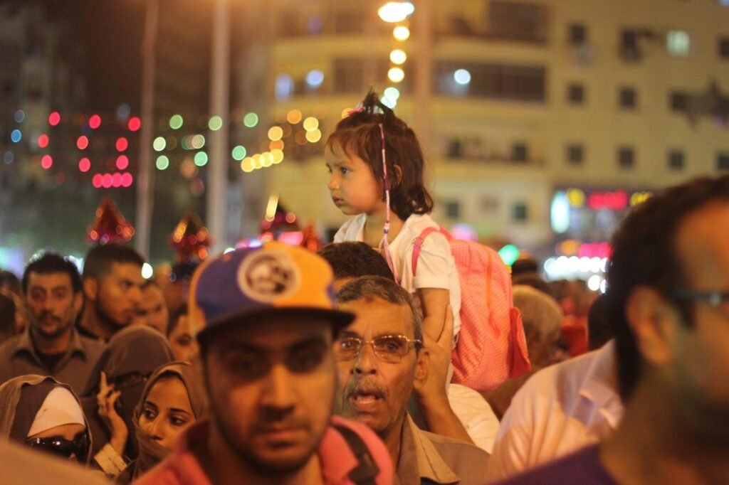 Women Carrying Children on Their Shoulders During Festive Mawlid Celebration – Cairo, Egypt