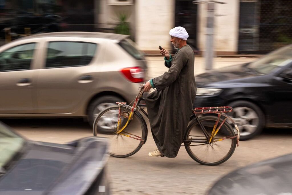 Saidi Man Riding a Bicycle While Using a Mobile Phone in Cairo 2