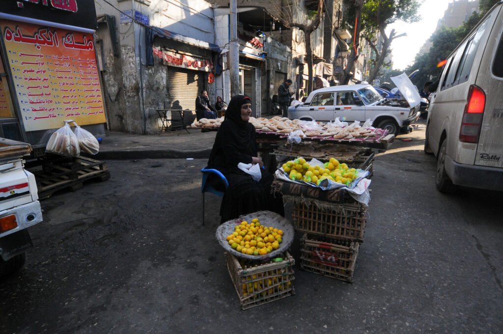 Elderly Woman Selling Traditional Bread and Lemons